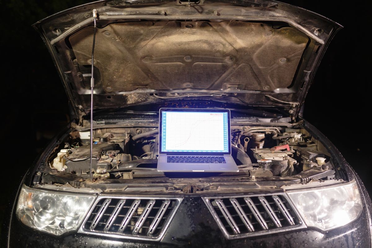 Laptop torque figures and horsepower is the engine of the vehicle for diagnostics and configuration. Diagnostic machines is ready for use with the car. Broken car in auto repair shop. Auto service.